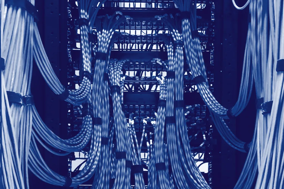 Sauber gebündelte Netzwerkkabel laufen geordnet in die Patchpanels eines Racks